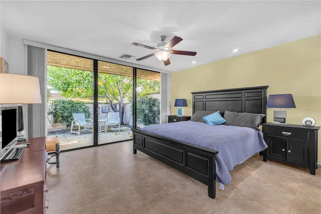 a bedroom with a bed flat screen tv and a large window