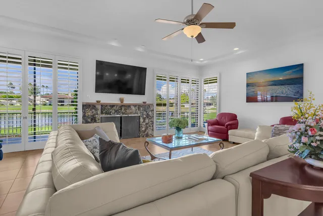 a living room with furniture a flat screen tv and a floor to ceiling window