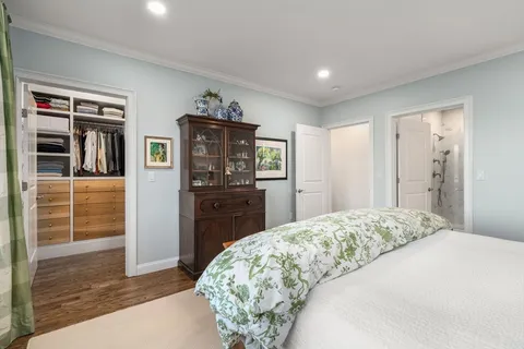 a spacious bedroom with a bed and dresser