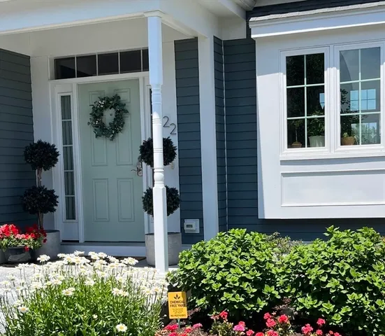 a front view of a house with a yard and flowers