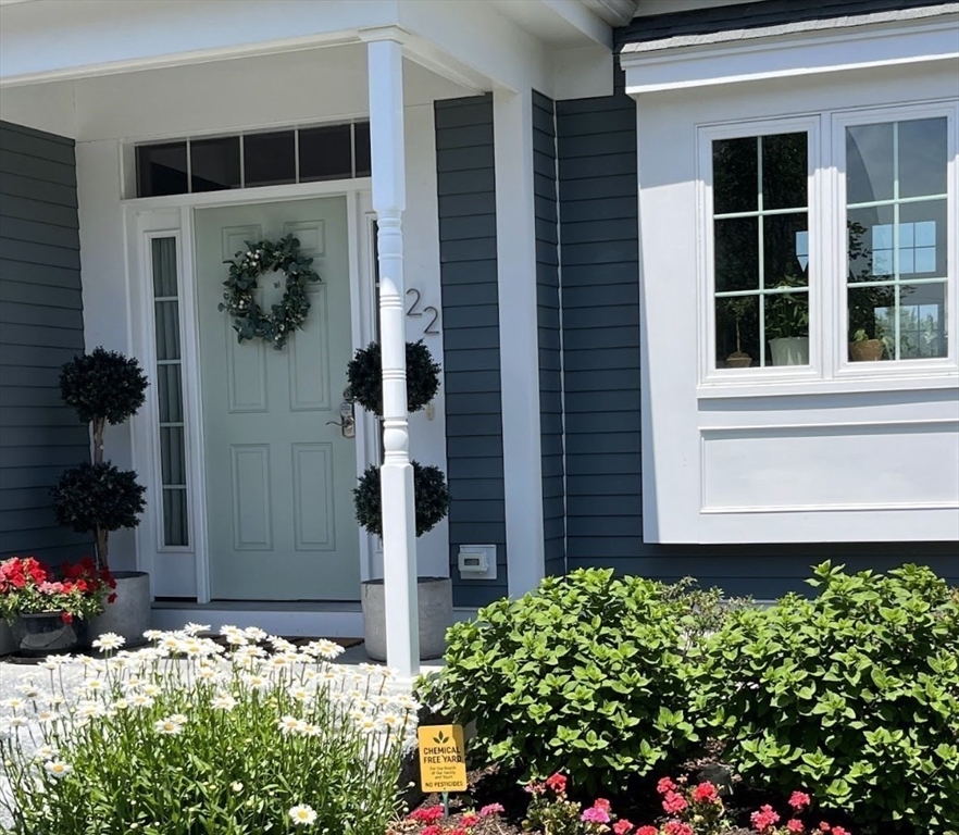 22 Sunset Way, Unit 22 Medfield, MA 02052 - Photo 3 of 42 a front view of a house with a yard and flowers