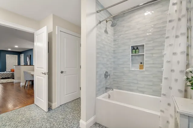 a bathroom with a tub a sink and a shower