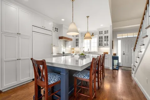 a dining room filled chandelier and wooden floor