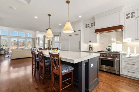 a kitchen with a stove a refrigerator and wooden floor