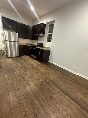 a large kitchen with a large counter top space stainless steel appliances and cabinets