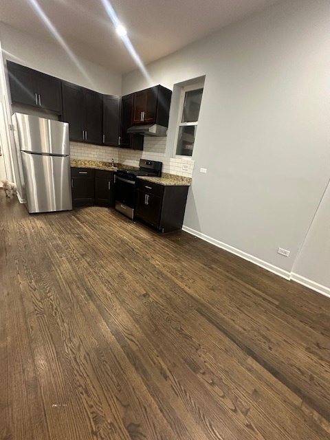 2829 West Polk Street, Unit 1 Chicago, IL 60612 - Photo 5 of 6 a large kitchen with a large counter top space stainless steel appliances and cabinets
