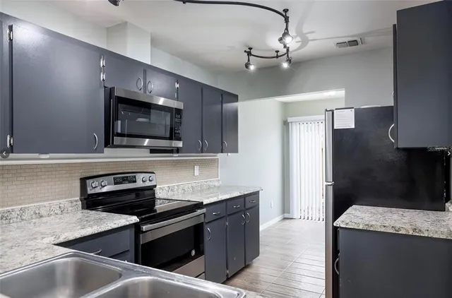 a kitchen with a sink stainless steel appliances and cabinets