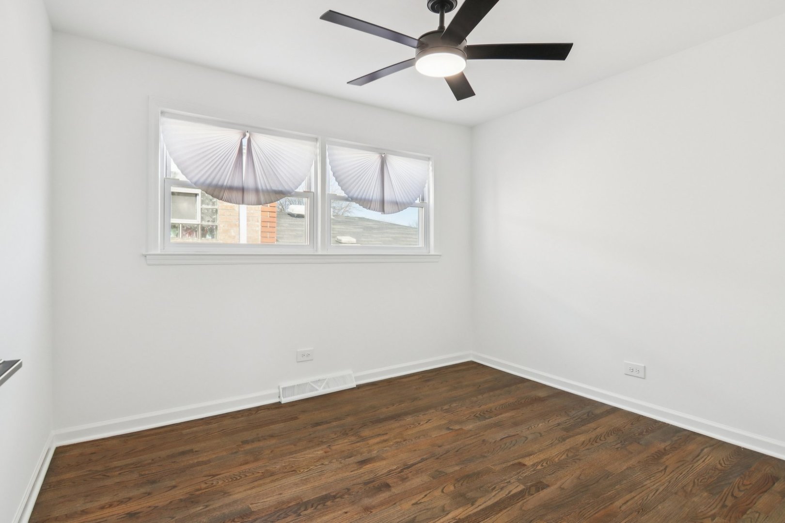 8630 South Indiana Avenue Chicago, IL 60619 - Photo 18 of 33 an empty room with wooden floor and windows