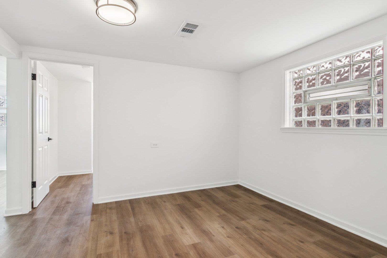 8630 South Indiana Avenue Chicago, IL 60619 - Photo 23 of 33 a view of an empty room with wooden floor and a window