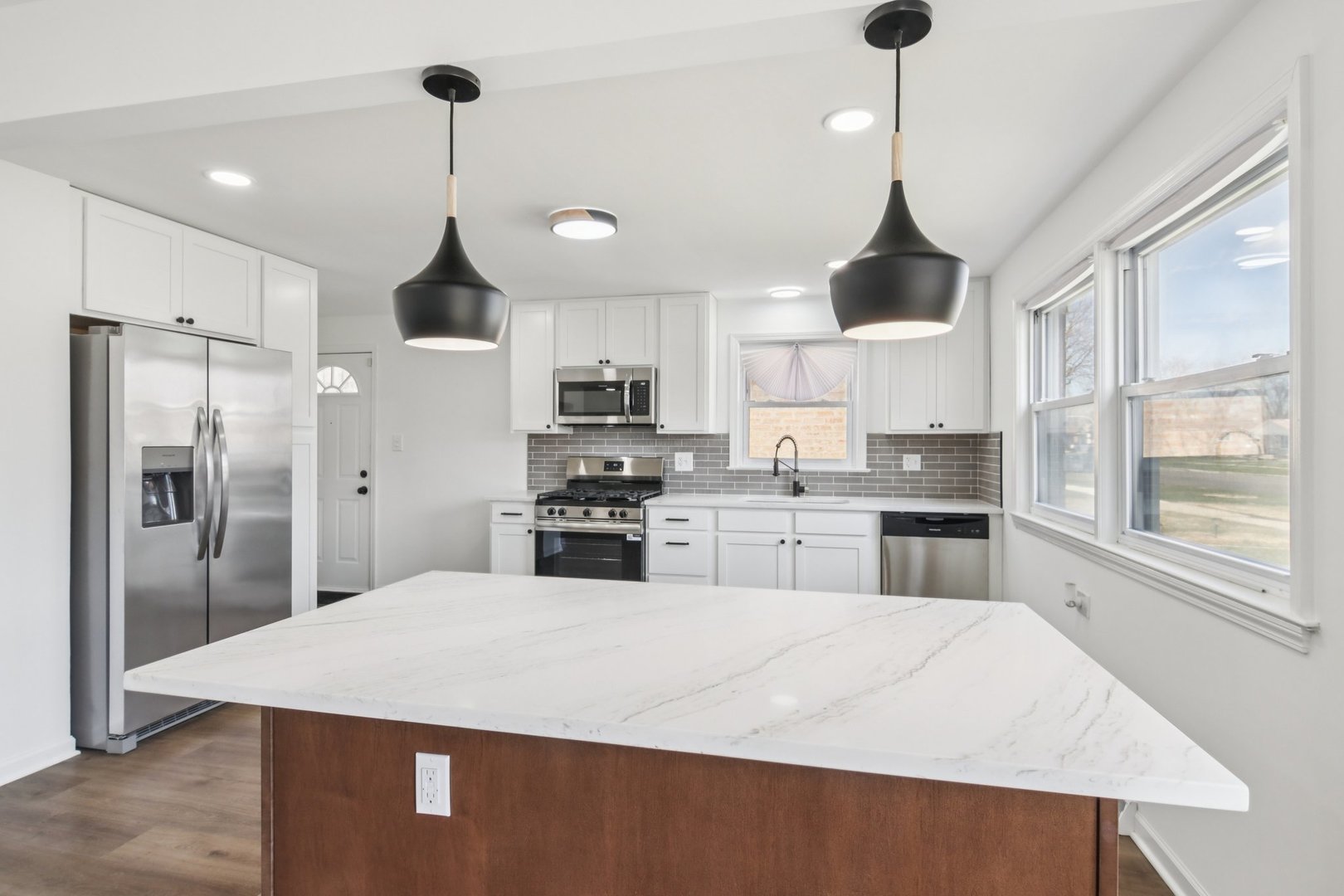8630 South Indiana Avenue Chicago, IL 60619 - Photo 10 of 33 a kitchen with stainless steel appliances kitchen island granite countertop a refrigerator a sink dishwasher a stove and white cabinets with wooden floor