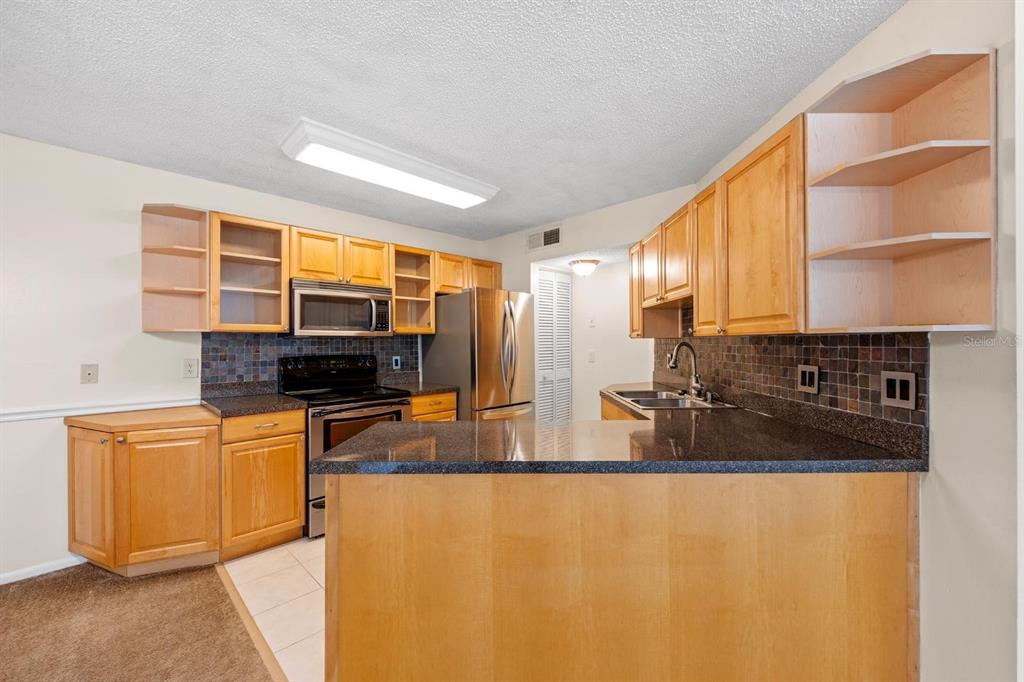1550 South Belcher Road, Unit 223 Clearwater, FL 33764 - Photo 11 of 38 a kitchen with stainless steel appliances granite countertop a sink and a refrigerator