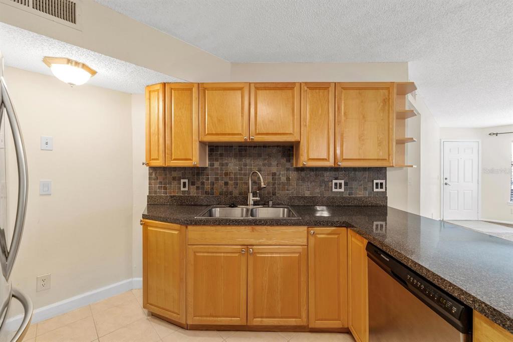 1550 South Belcher Road, Unit 223 Clearwater, FL 33764 - Photo 12 of 38 a kitchen with stainless steel appliances granite countertop a sink a stove cabinets and a window
