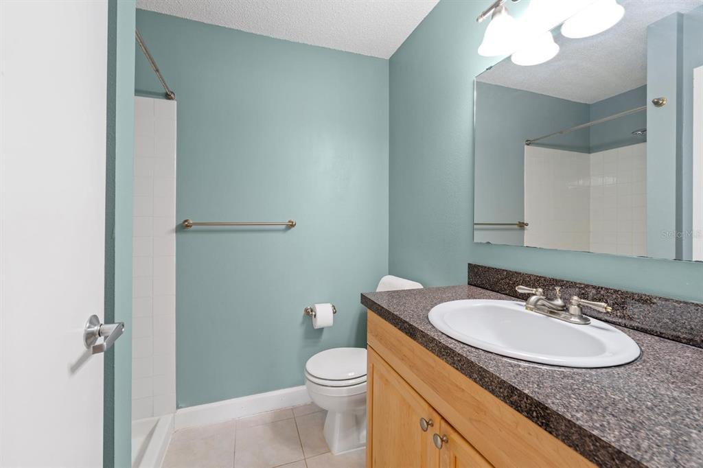 1550 South Belcher Road, Unit 223 Clearwater, FL 33764 - Photo 19 of 38 a bathroom with a granite countertop sink toilet and a mirror