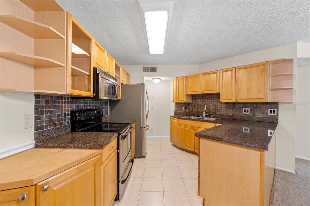 1550 South Belcher Road, Unit 223 Clearwater, FL 33764 - Photo 10 of 38 a kitchen with stainless steel appliances granite countertop a sink and a stove
