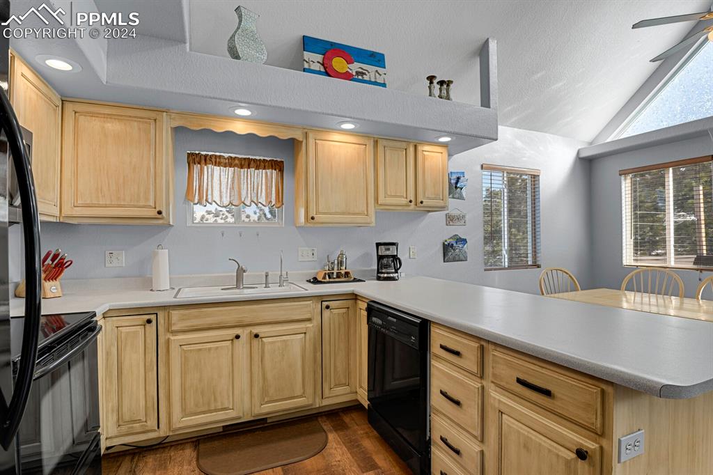 998 Bunker Hill Road Silver Cliff, CO 81252 - Photo 12 of 49 a kitchen with a sink dishwasher and white cabinets with wooden floor