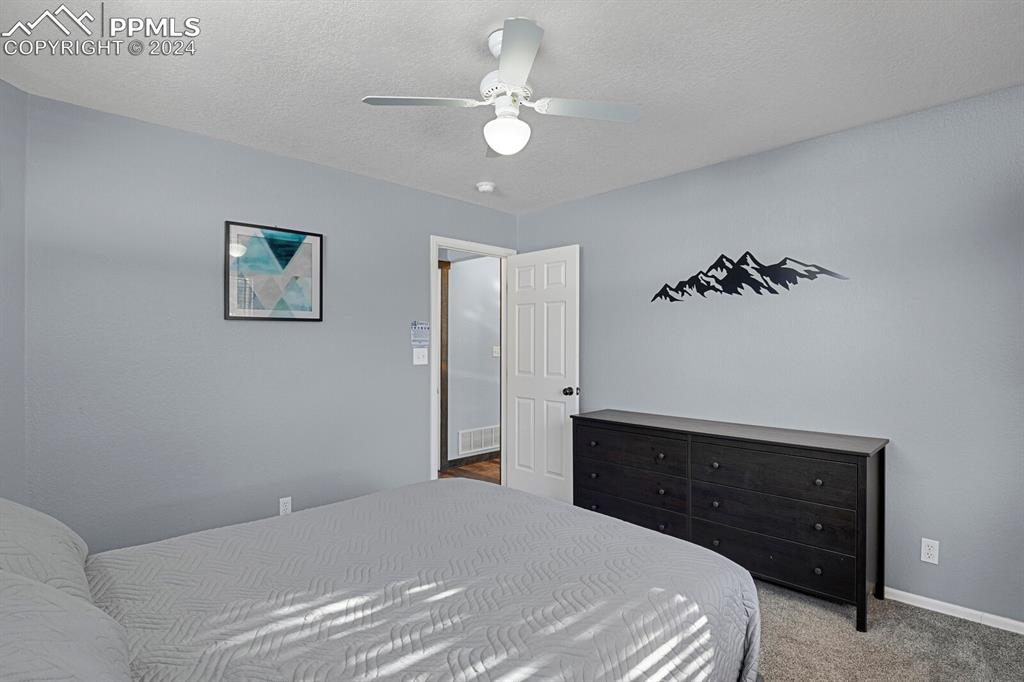 998 Bunker Hill Road Silver Cliff, CO 81252 - Photo 8 of 49 a bedroom with a bed and a lamp on dresser