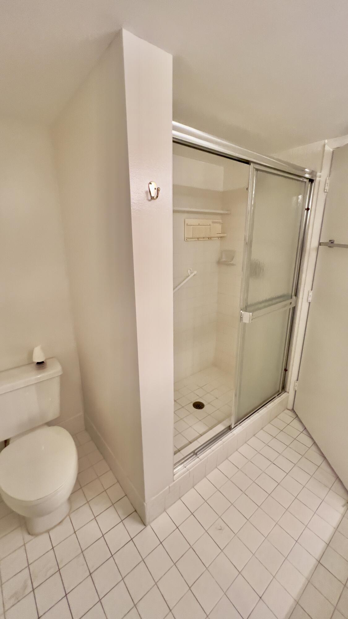 6121 Pointe Regal Circle, Unit 209 Delray Beach, FL 33484 - Photo 17 of 41 a bathroom with a shower and toilet