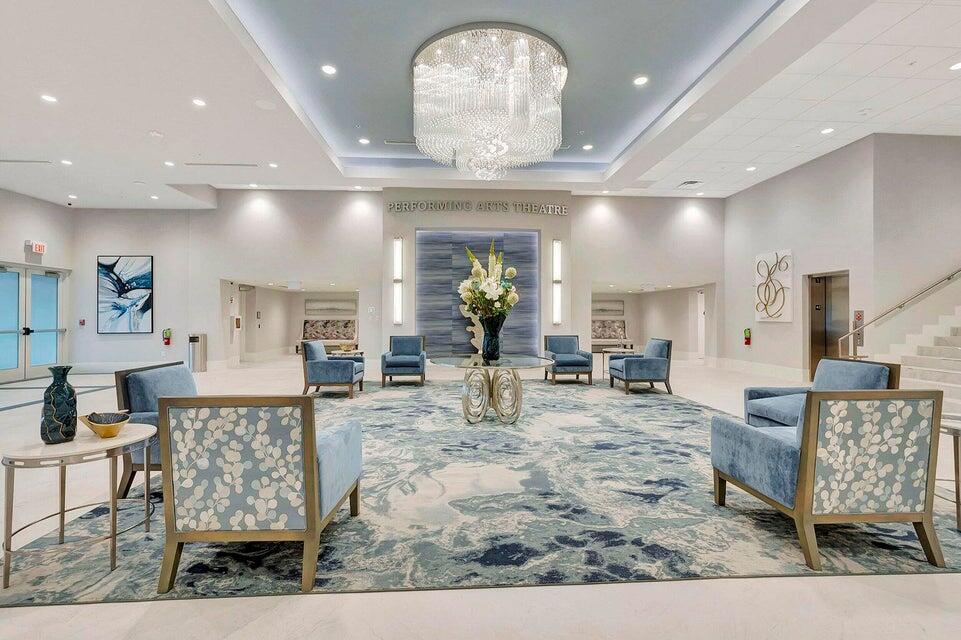 6121 Pointe Regal Circle, Unit 209 Delray Beach, FL 33484 - Photo 29 of 41 a living room with furniture and a chandelier
