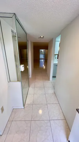 a view of a hallway to rooms and stairs