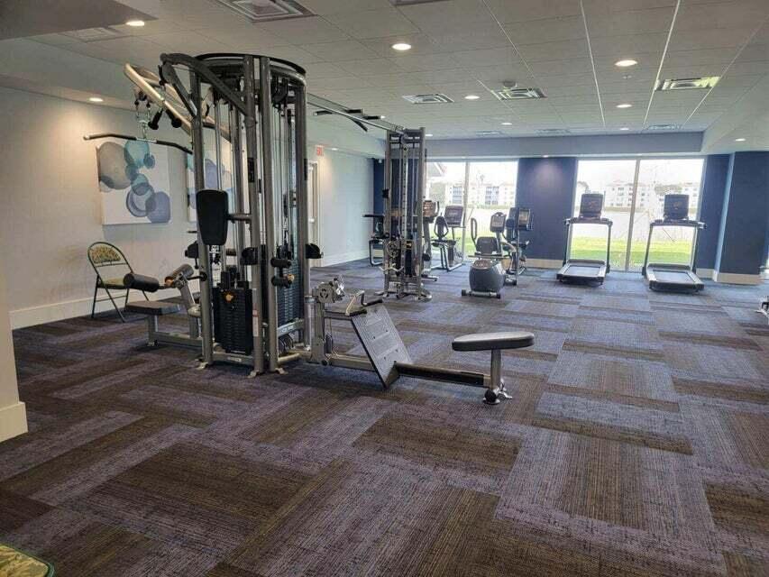 6121 Pointe Regal Circle, Unit 209 Delray Beach, FL 33484 - Photo 35 of 41 a living room filled with furniture gym equipment and a large window
