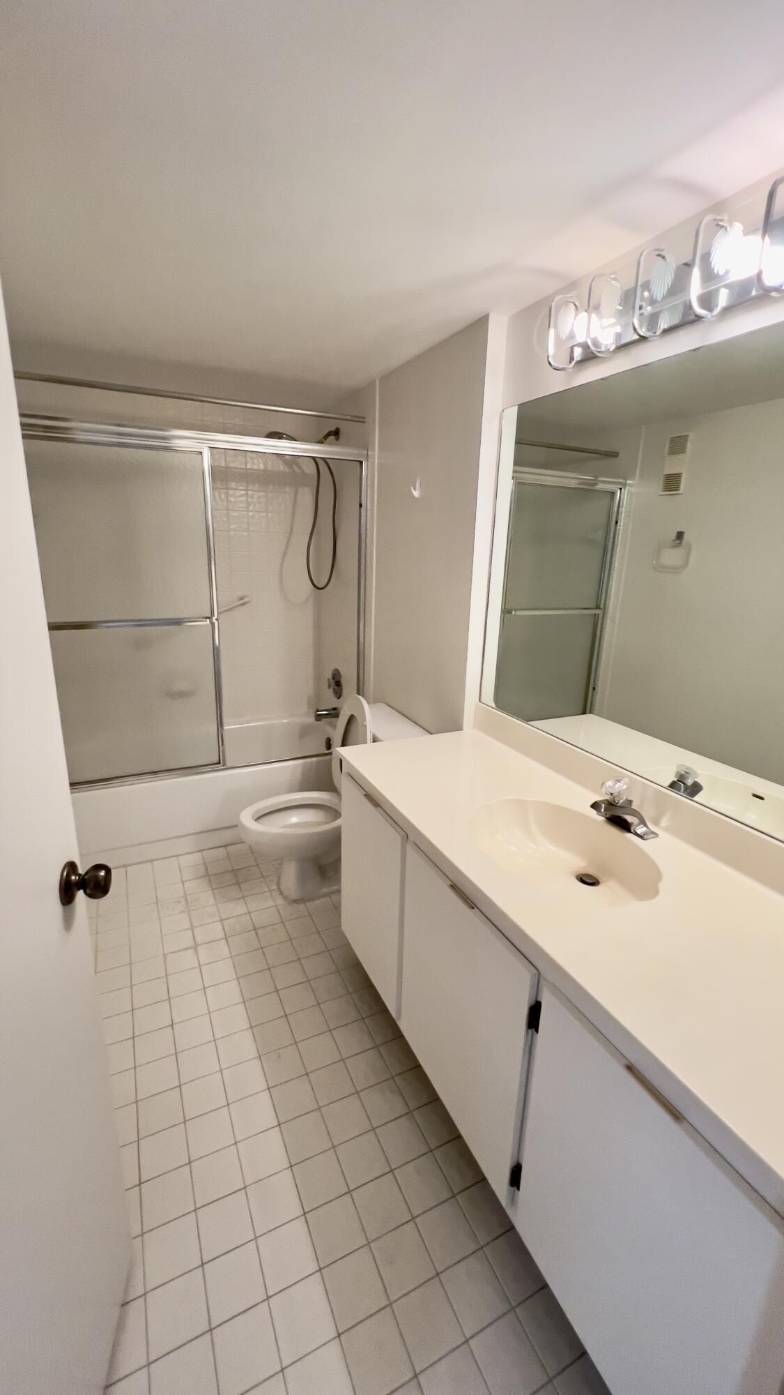 6121 Pointe Regal Circle, Unit 209 Delray Beach, FL 33484 - Photo 9 of 41 a bathroom with a double vanity sink mirror and bathtub