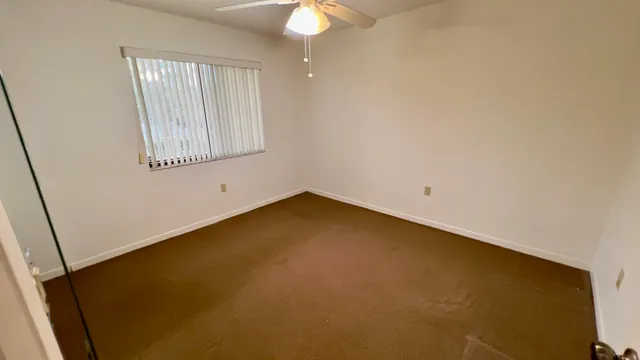 a view of an empty room with a ceiling fan