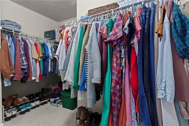 a view of walk in closet with clothes