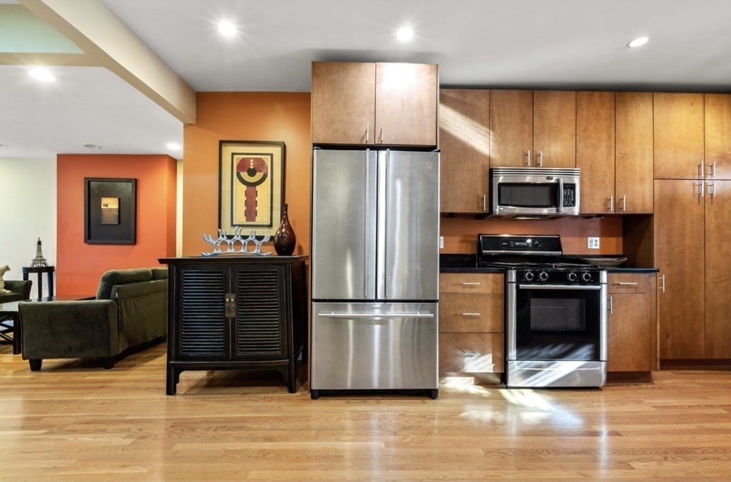 a kitchen with stainless steel appliances a stove refrigerator and microwave