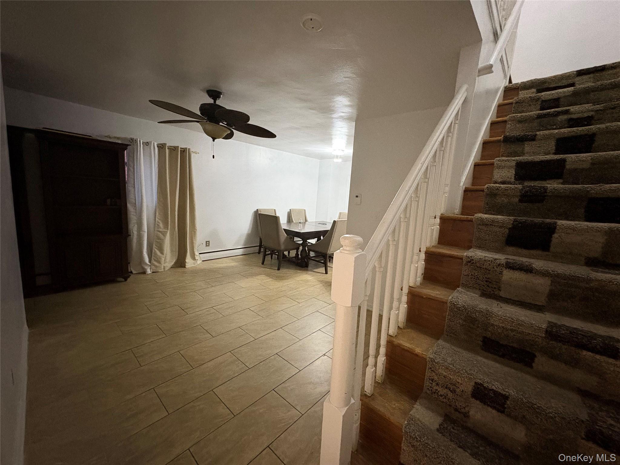 269 Balcom Avenue Bronx, NY 10465 - Photo 11 of 20 Basement featuring stairway, a ceiling fan, a baseboard radiator, and wood finished floors
