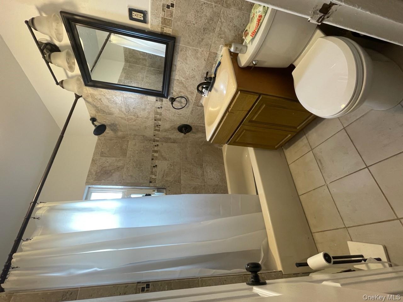 269 Balcom Avenue Bronx, NY 10465 - Photo 13 of 20 Full bath with tile walls, shower / bath combo, vanity, and tile patterned flooring