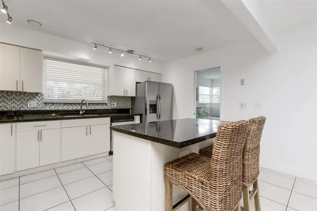 a kitchen with stainless steel appliances kitchen island granite countertop a sink and cabinets