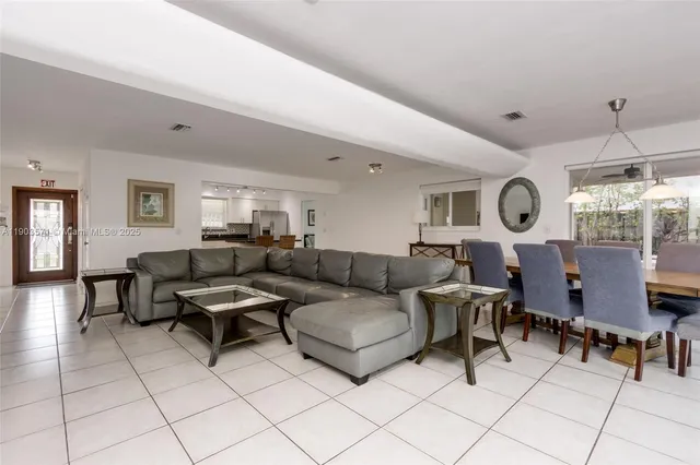 a living room with furniture a dining table and a clock