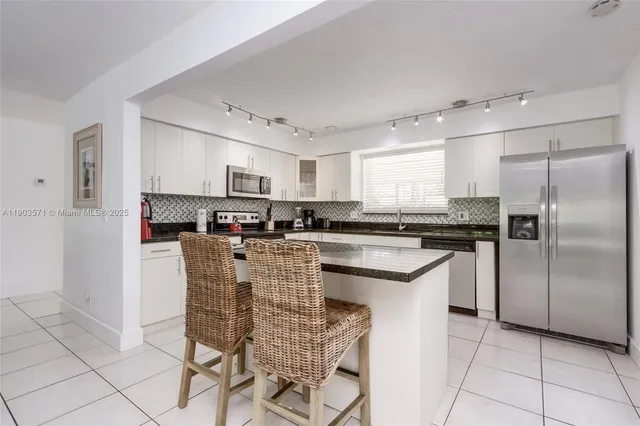a kitchen with stainless steel appliances granite countertop a refrigerator and a stove top oven