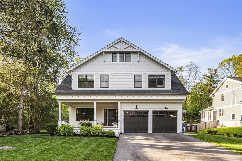 a view of a white house with a yard and large tree