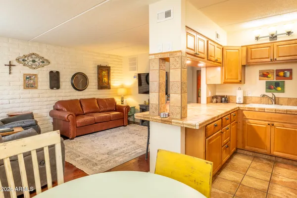 a living room with furniture and a open kitchen view
