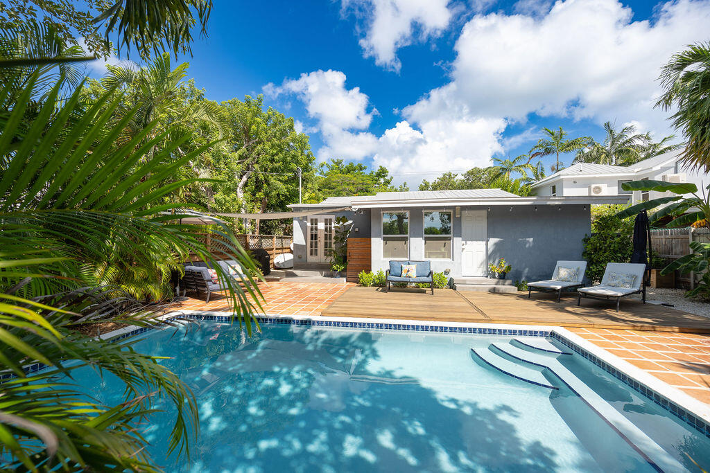 a view of a house with swimming pool and sitting area
