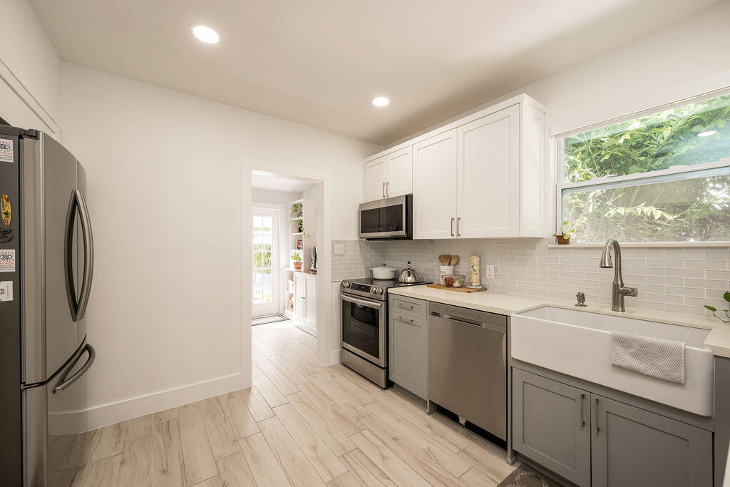 3402 Eagle Avenue Key West, FL 33040 - Photo 4 of 27 a kitchen with a sink a window a counter top space stainless steel appliances and cabinets