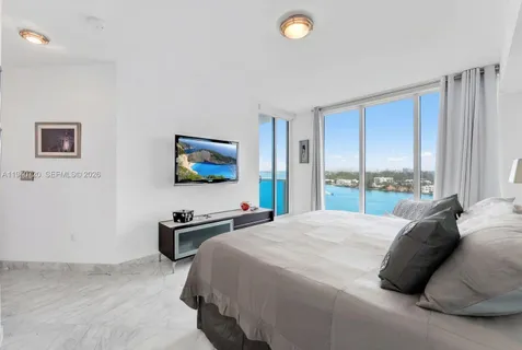 a bedroom with a bed and a flat screen tv