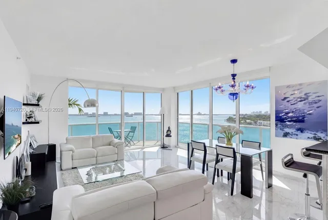 a living room with furniture a floor to ceiling window and a flat screen tv