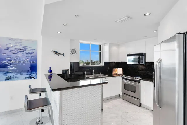 a kitchen with stainless steel appliances a stove refrigerator sink and microwave