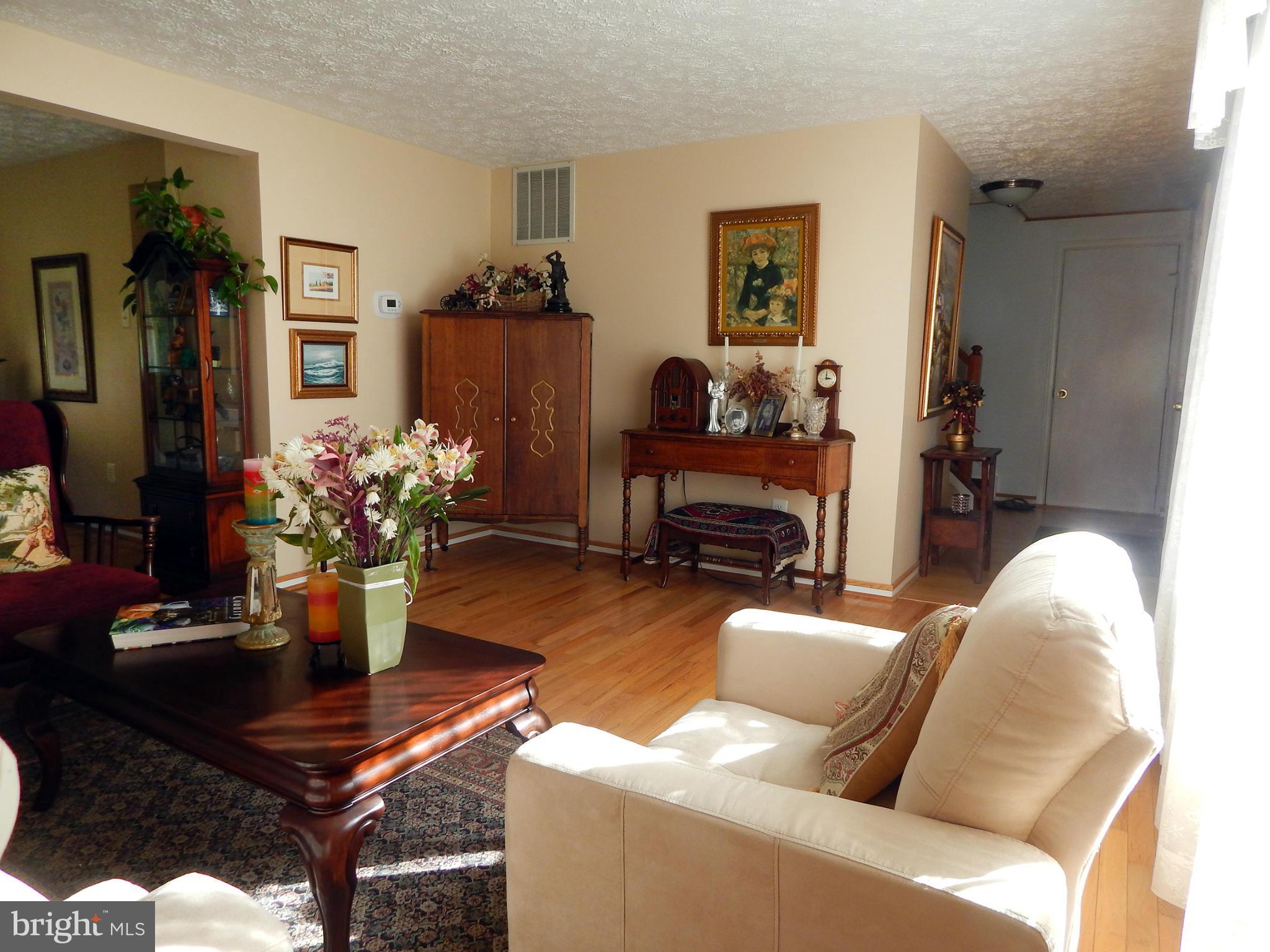 5776 Heming Avenue Springfield, VA 22151 - Photo 6 of 25 a living room with furniture a piano and a flat screen tv