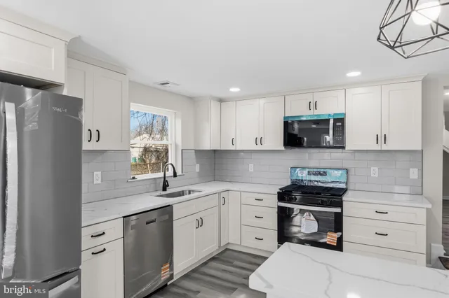 a kitchen with a sink a stove a refrigerator and cabinets