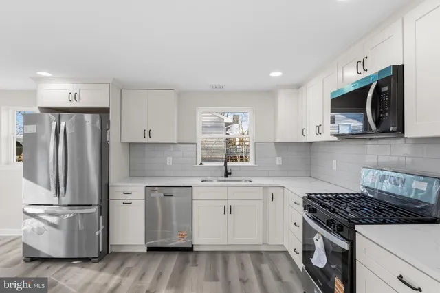 a kitchen with stainless steel appliances granite countertop a stove a refrigerator and a microwave