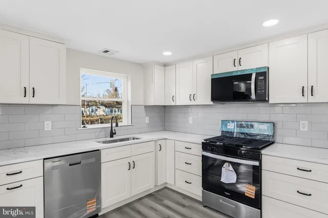 a kitchen with stainless steel appliances white cabinets and sink