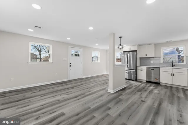 a view of a kitchen with wooden floor electronic appliances and window