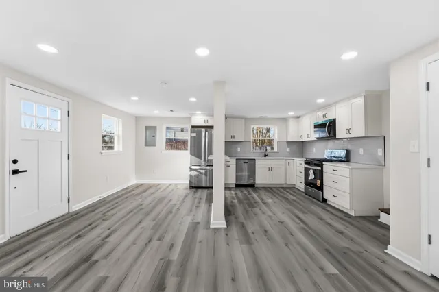 a view of kitchen with wooden floor and electronic appliances