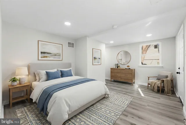 a bedroom with a bed lamp closet and three large window