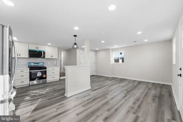 a view of kitchen with microwave a stove and wooden floor