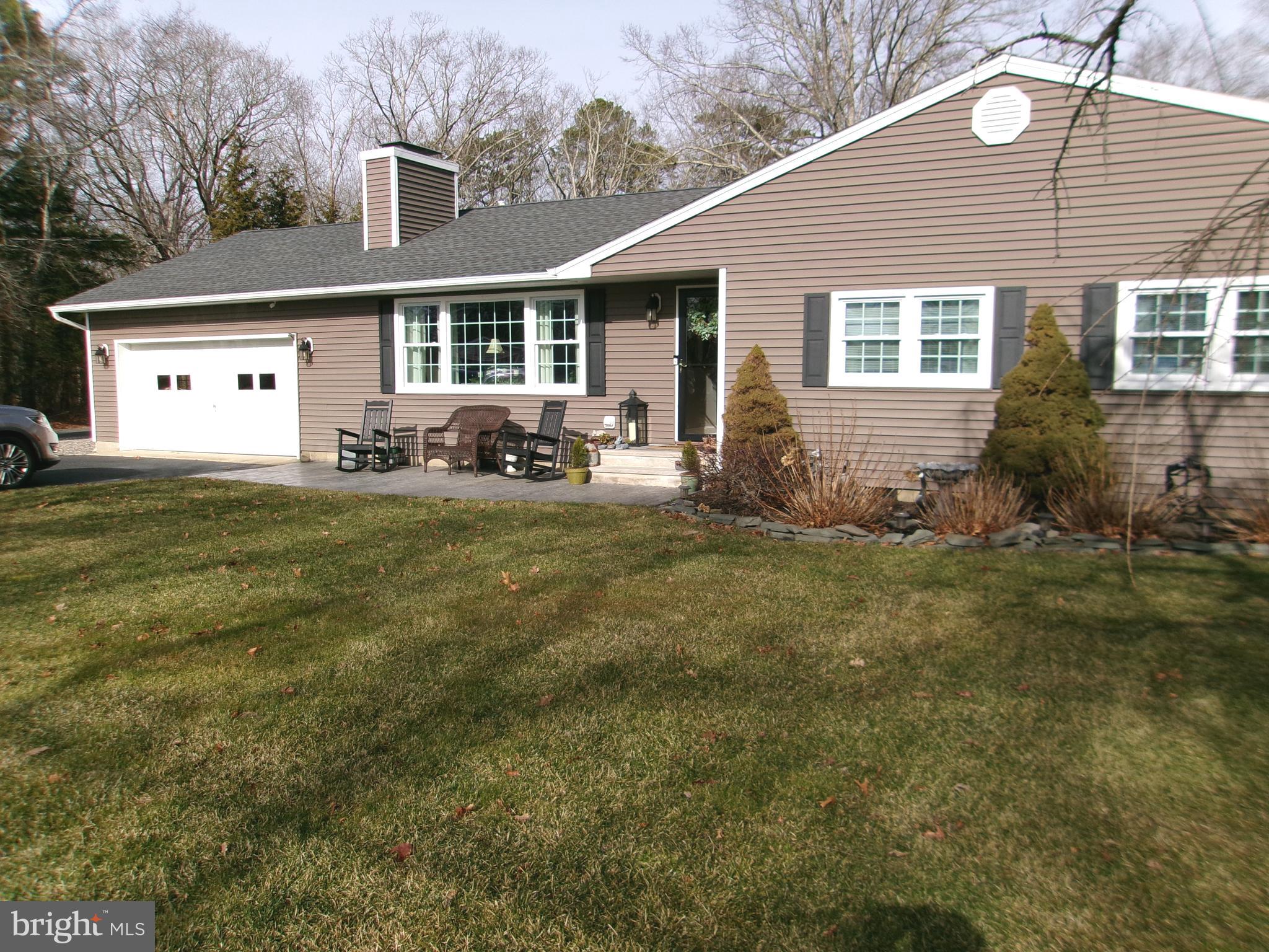 a view of a yard in front of a house with large windows