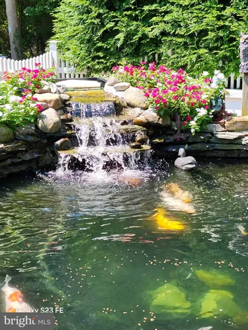 a view of a lake with a table and chairs and potted plants